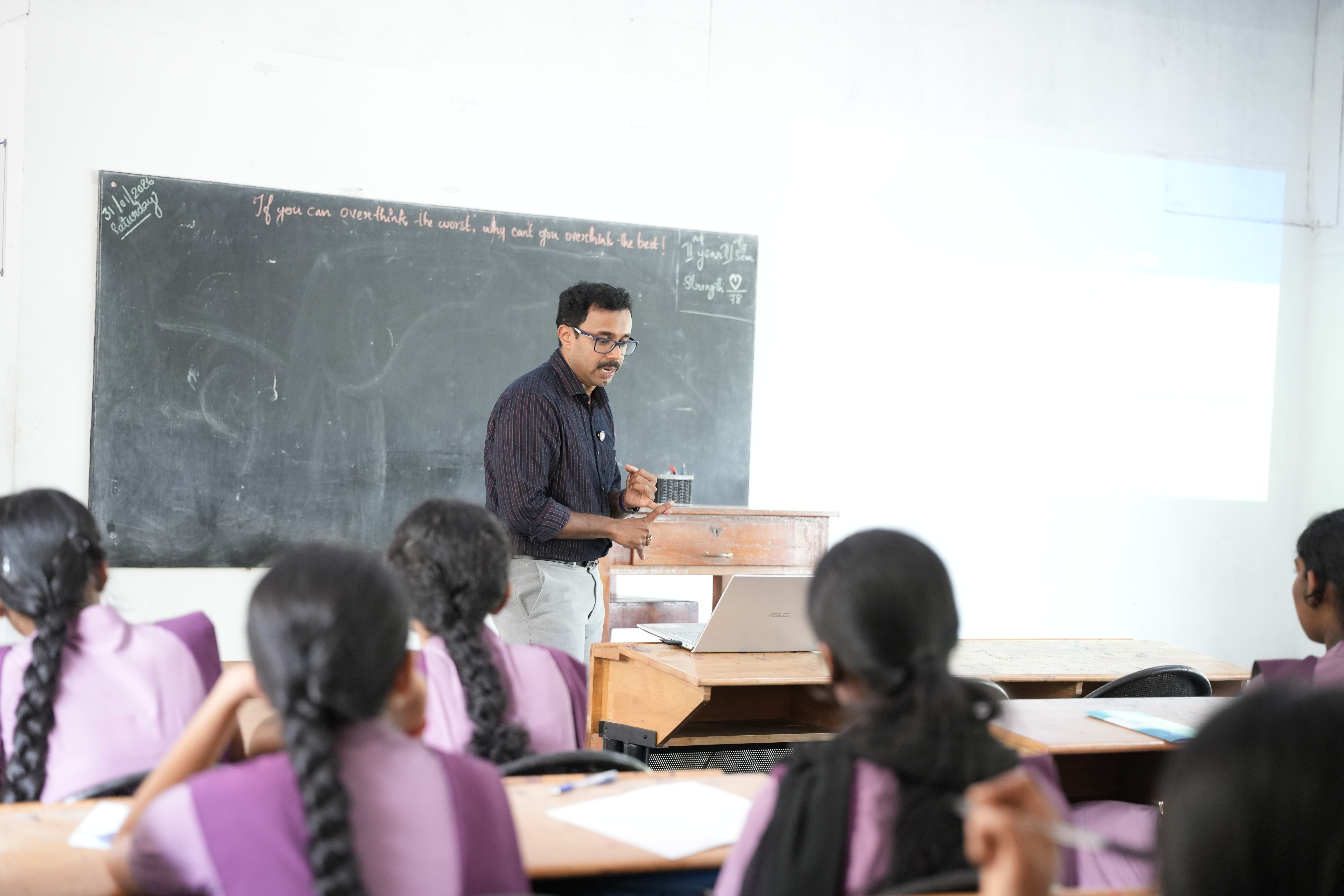 Students in purple uniforms listening attentively during a classroom session