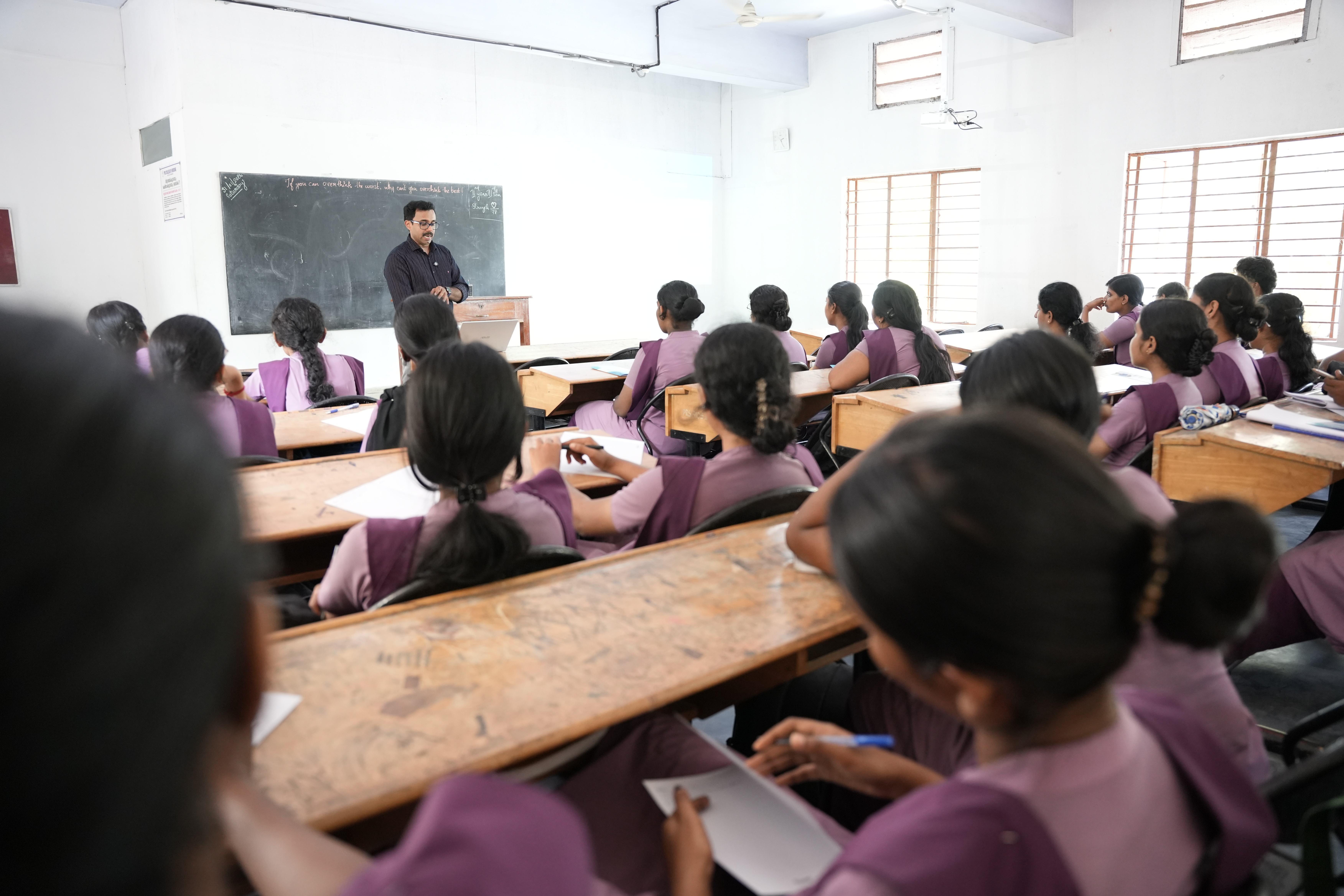 Students taking notes at their desks during a lecture at Eduooz