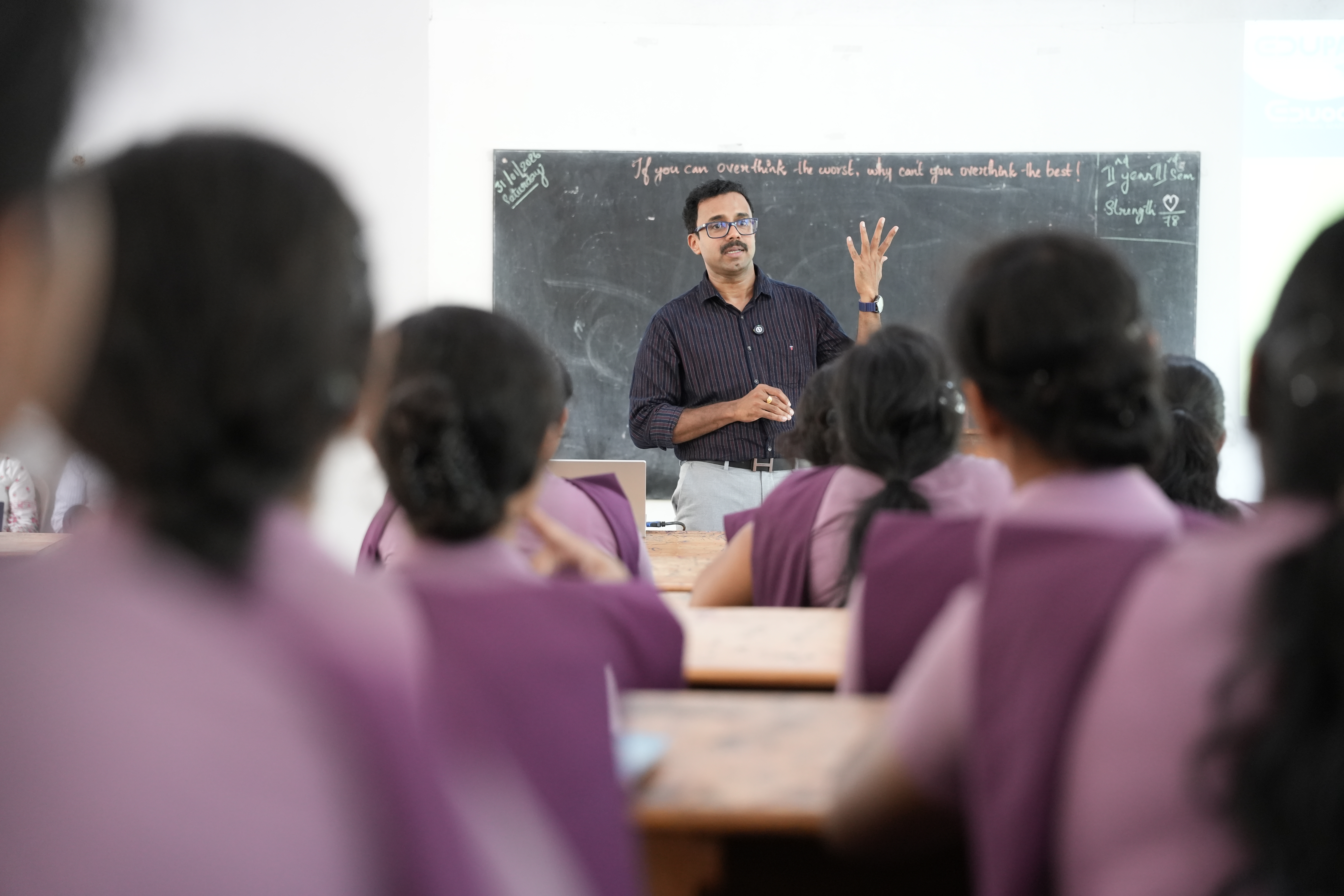 Student receiving guidance from a mentor beside the blackboard