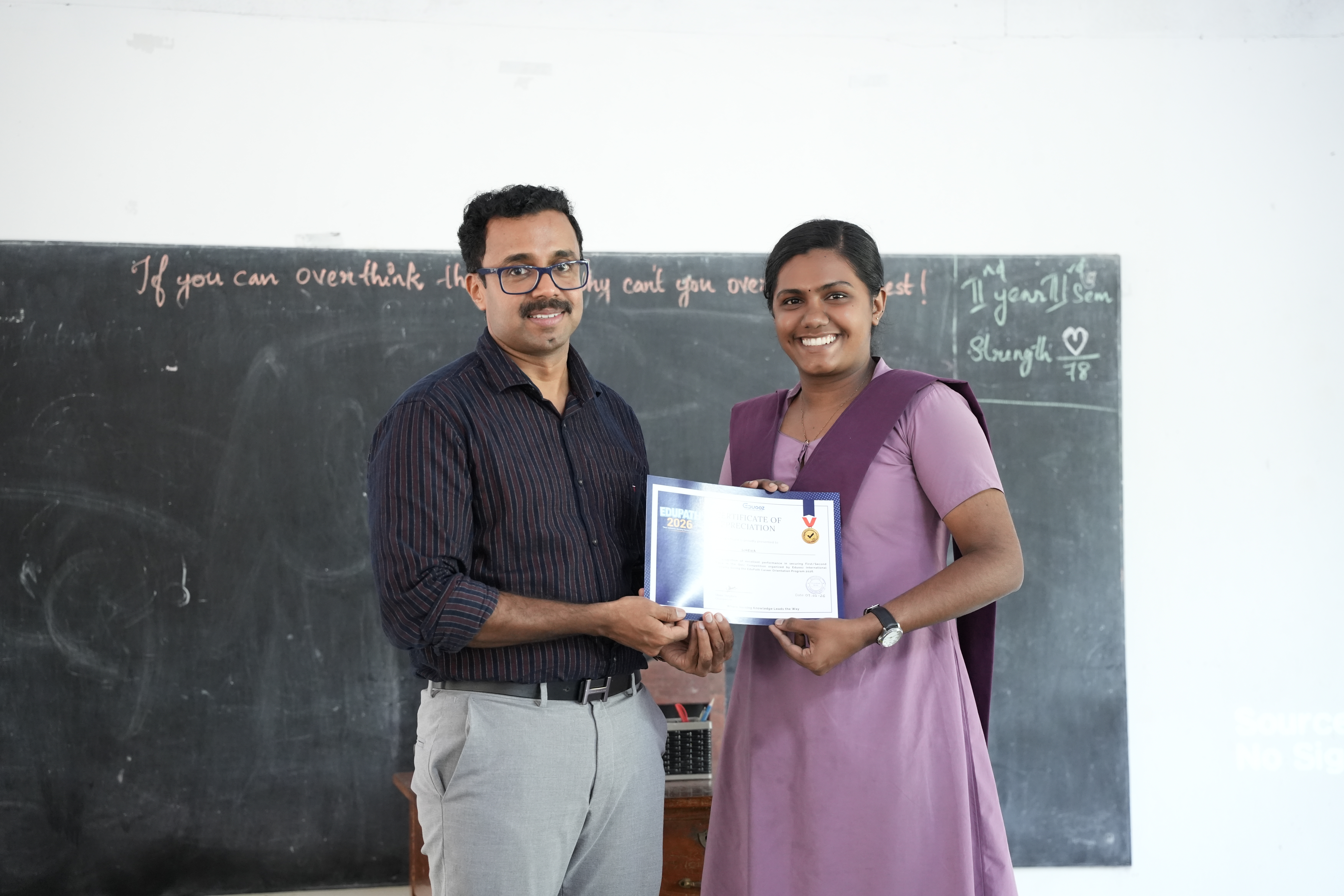 Student smiling while holding a certificate of appreciation